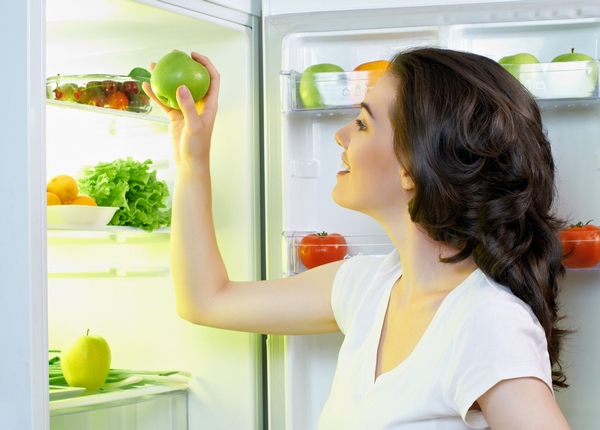  Girl puts an apple in the fridge