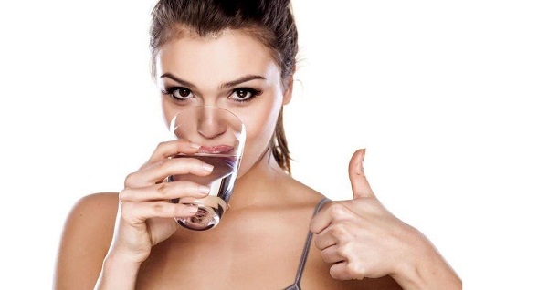  The girl drinks water from a glass