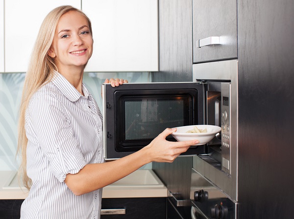  Woman puts a plate in the microwave