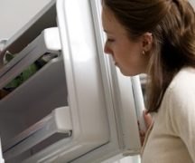  The girl looks into the freezer