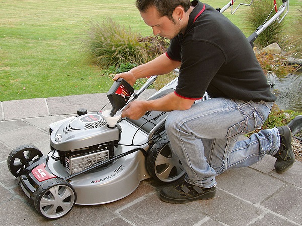  Pouring oil into the lawn mower