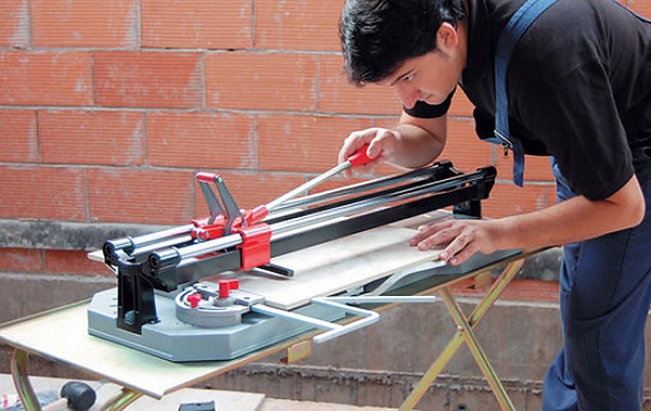  Man cuts tile tile cutter